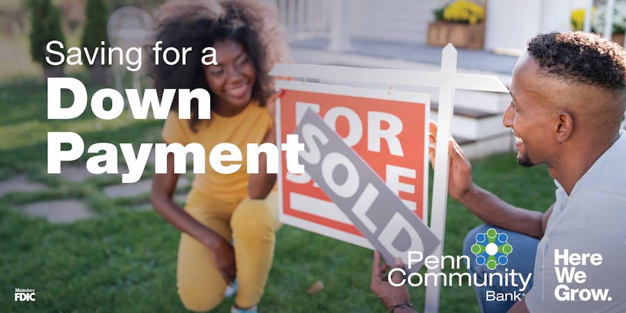 saving for a down payment image, two new homeowners crouching in front of a sold house and smiling at each other